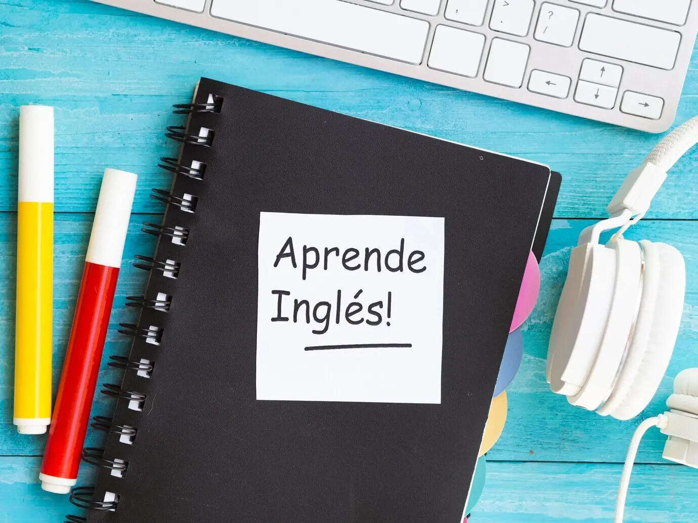 Draufsicht auf eine beschriebene Haftnotiz auf einem Notizbuch.